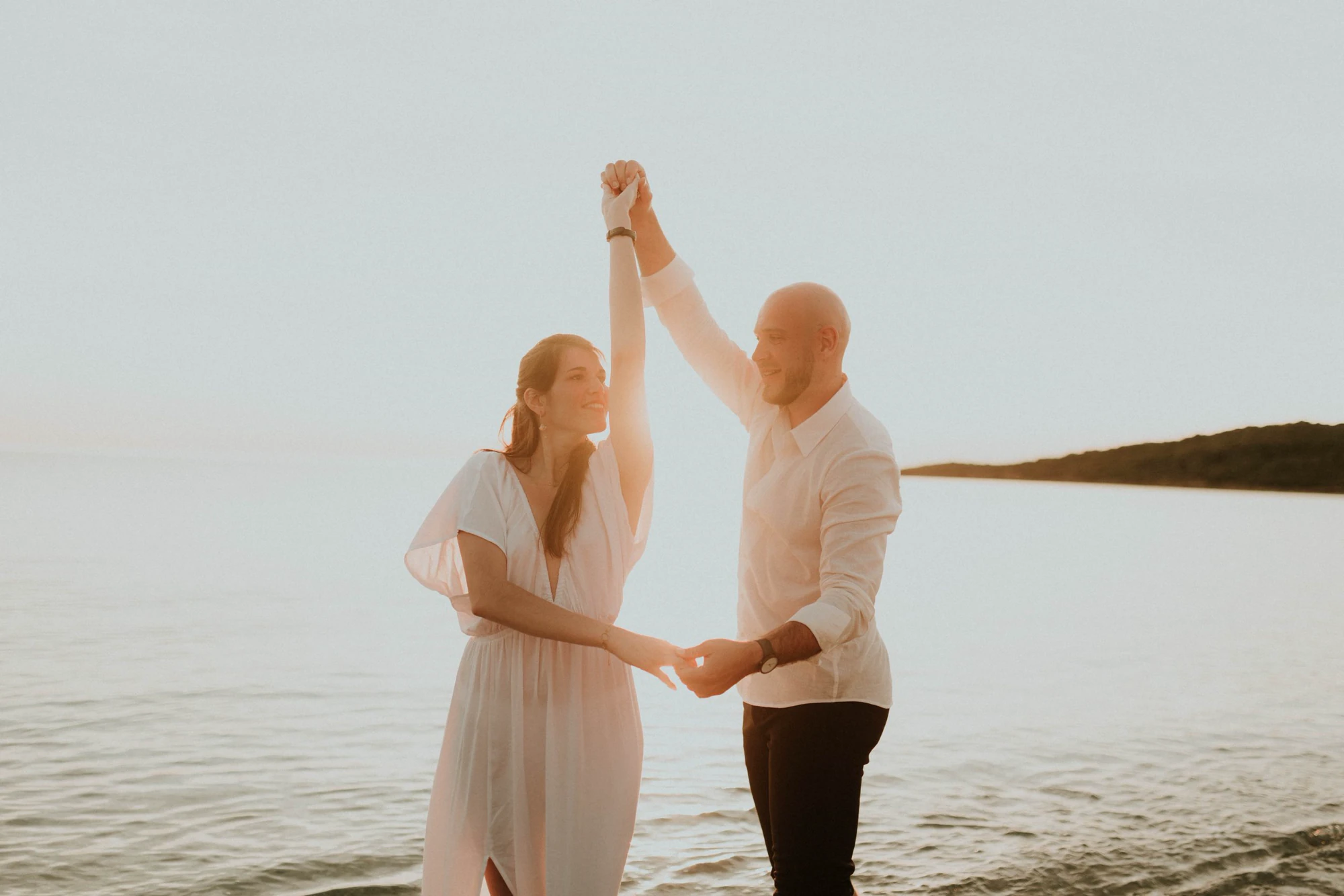 Couple dancing in the sea at sunset on Capo di Feno beach, Corsica