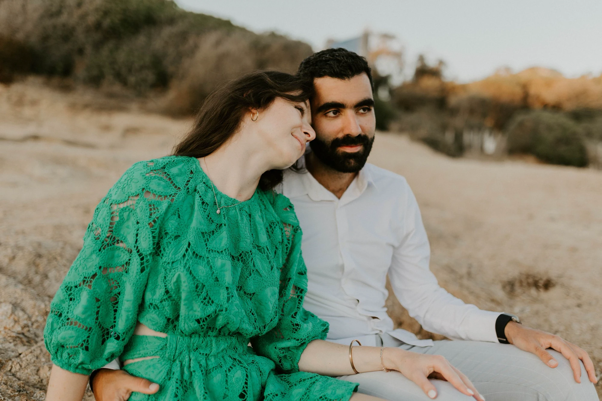 Couple sitting on the sand at golden hour, Capo di Feno
